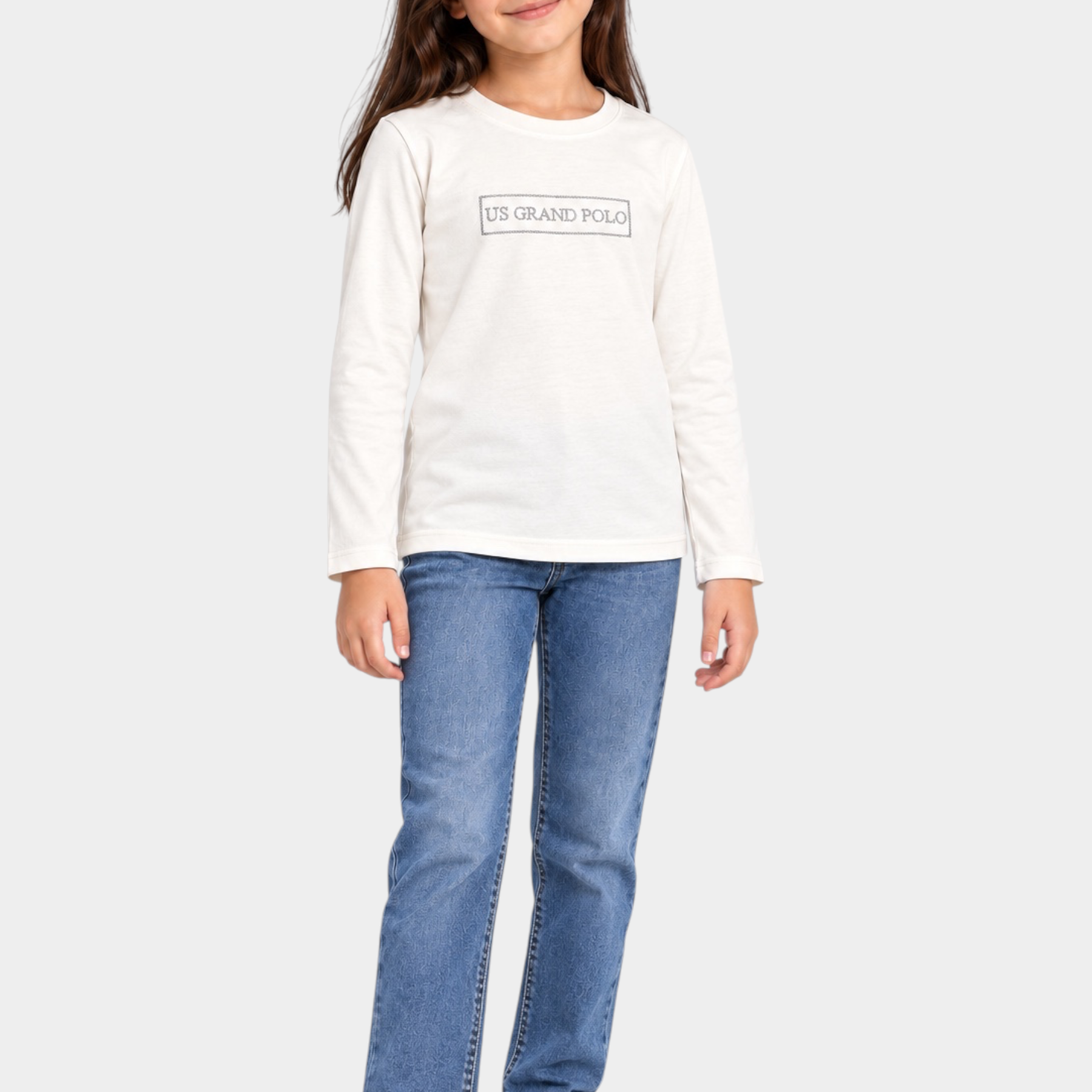 Bambina che indossa una t-shirt bianca a maniche lunghe Follower SRL con logo US GRAND POLO decorato con strass
