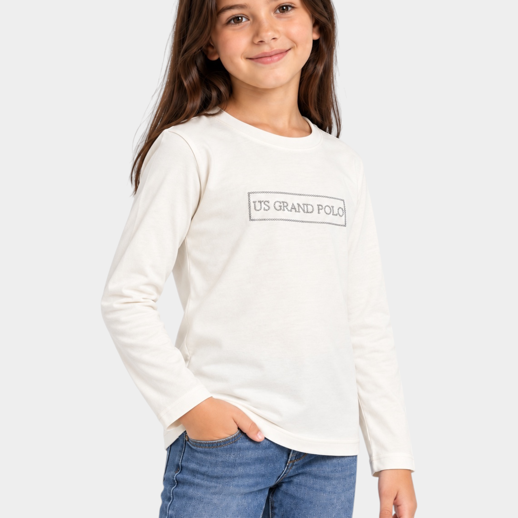 Bambina indossa una t-shirt bianca a maniche lunghe Follower SRL con logo US GRAND POLO decorato con strass