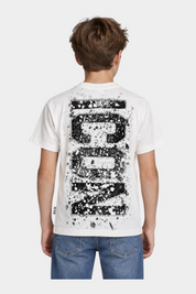 Ragazzo indossa una t-shirt bianca Follower SRL con grande stampa nera ICON effetto schizzi di vernice sul retro