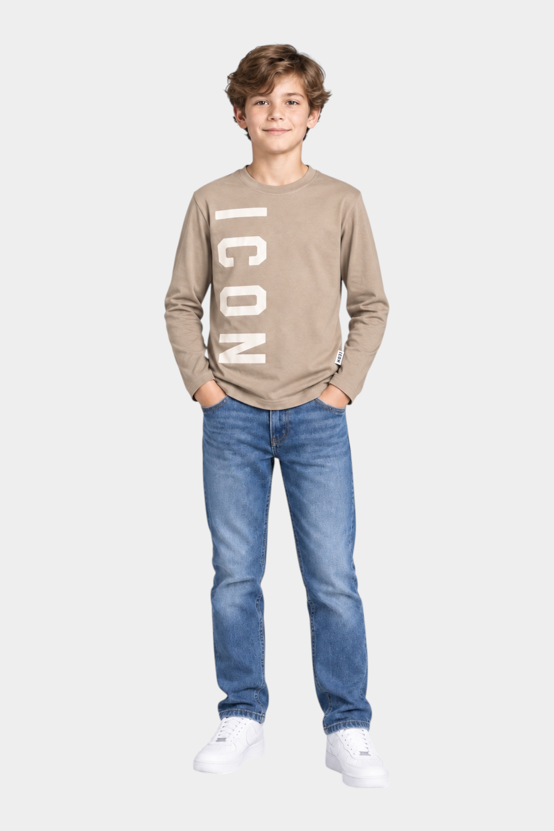 Ragazzo indossa Follower SRL t-shirt beige a maniche lunghe con stampa ICON bianca, jeans blu e sneakers bianche