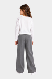 Bambina indossa t-shirt bianca a maniche lunghe Follower SRL con pantaloni grigi a gamba larga