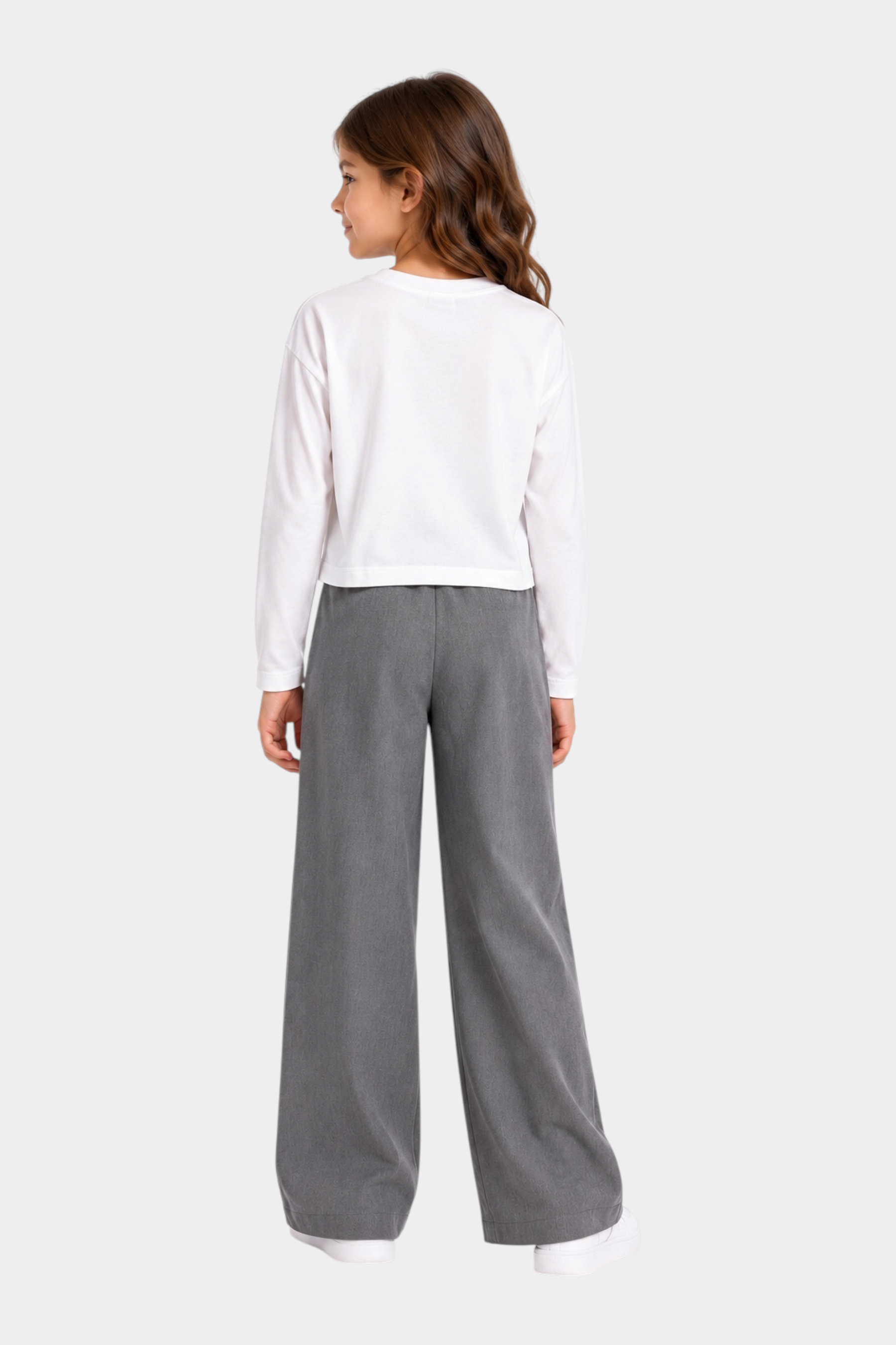 Bambina indossa t-shirt bianca a maniche lunghe Follower SRL con pantaloni grigi a gamba larga