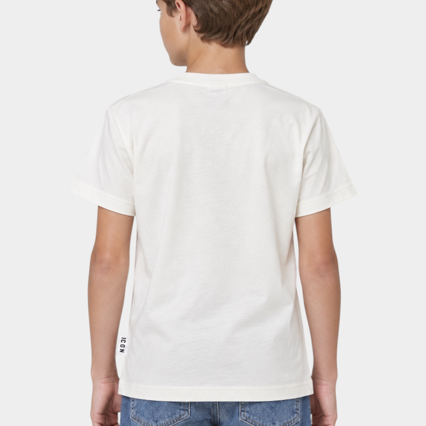 Ragazzo di spalle indossa una T-shirt bianca Follower SRL in cotone con etichetta laterale ICON e jeans blu