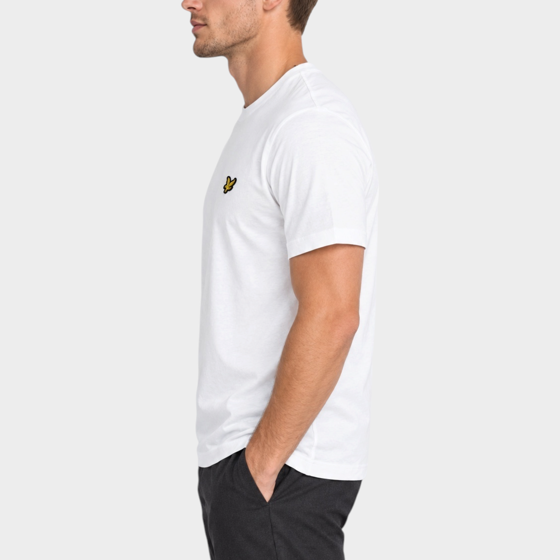 Modello indossa t-shirt bianca Follower SRL Lyle & Scott con logo ricamato sul petto, vista laterale
