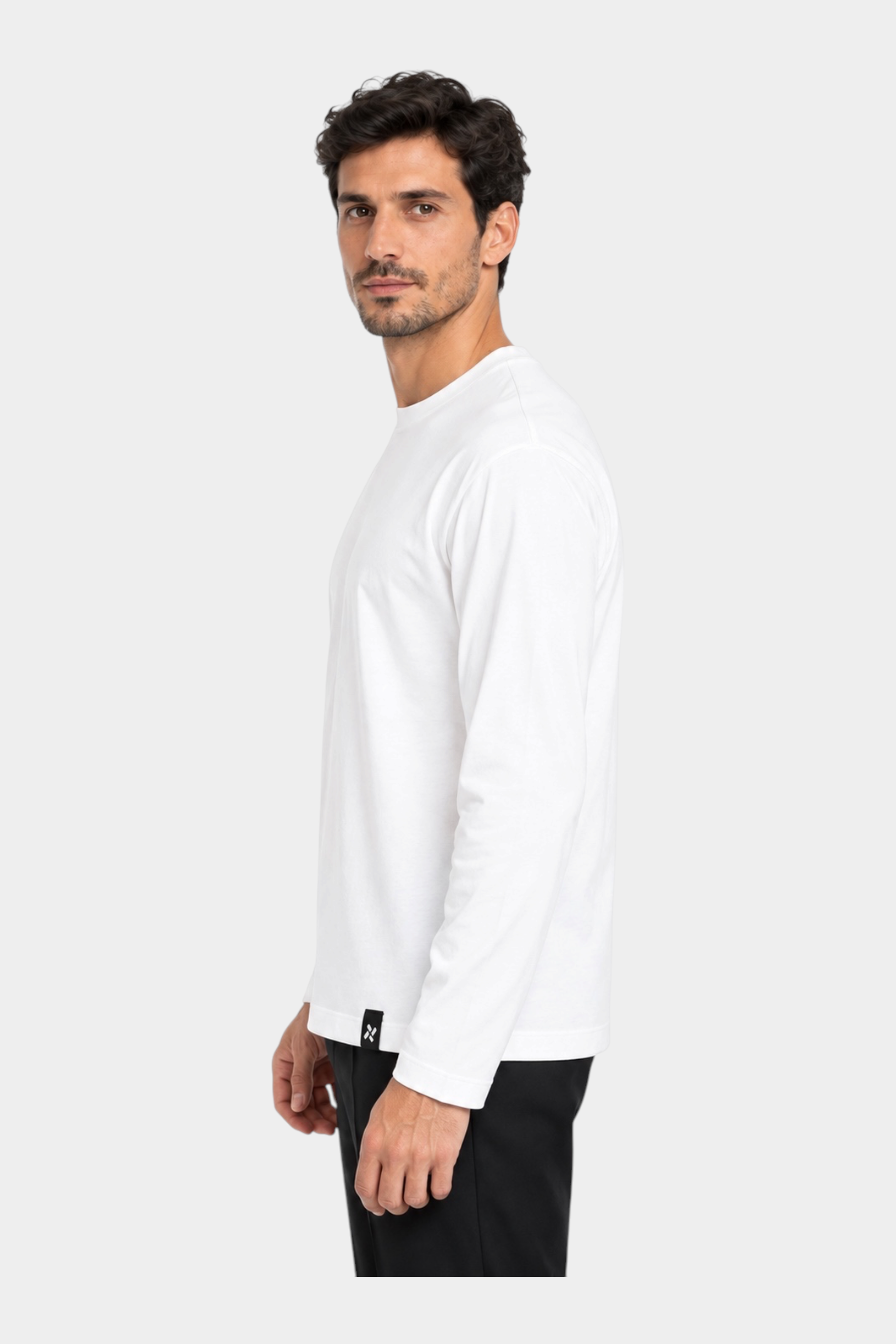 Modello indossa t-shirt bianca a manica lunga Follower SRL con vestibilità regular e dettaglio logo sul polsino