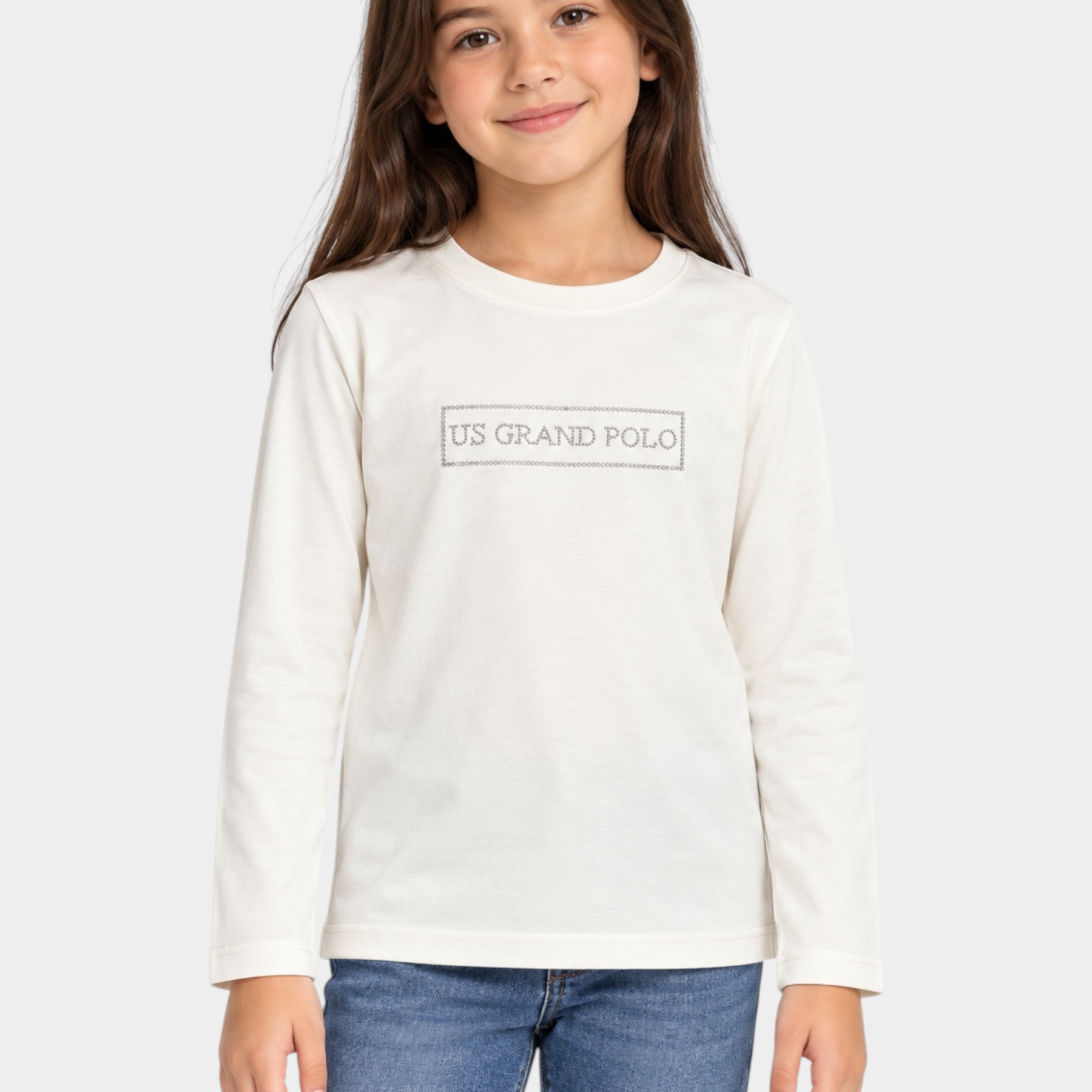 Bambina indossa una t-shirt bianca a maniche lunghe Follower SRL con scritta US GRAND POLO decorata con strass