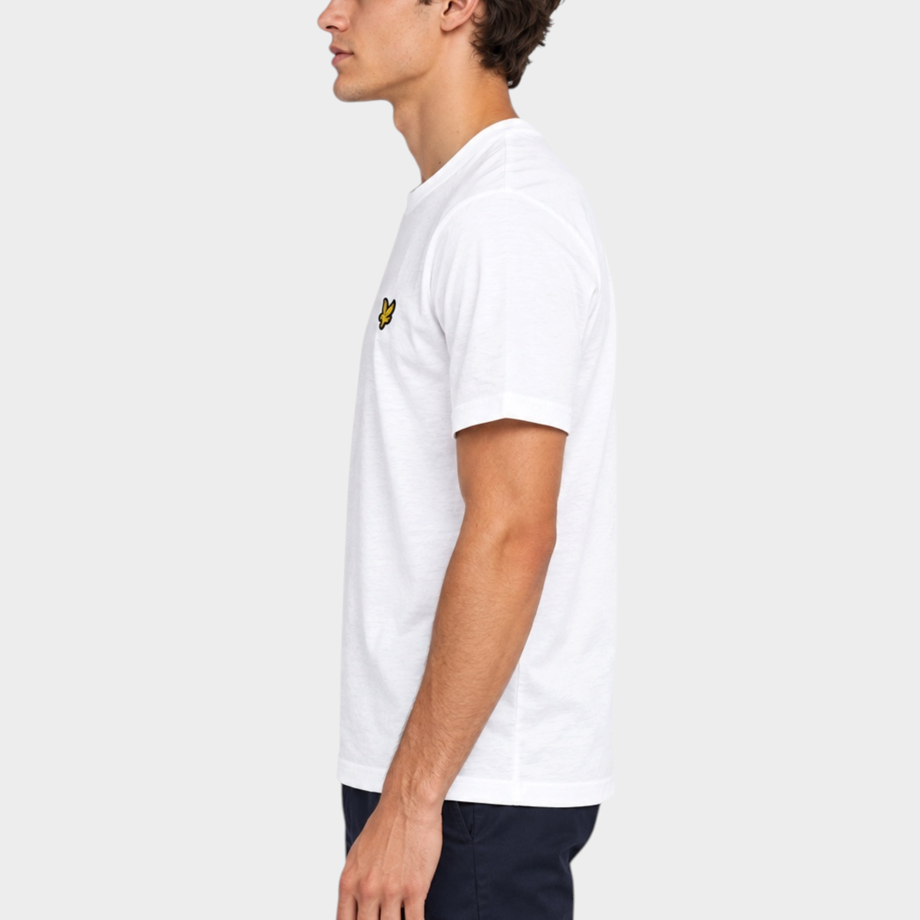 Modello indossa t-shirt bianca in cotone Follower SRL con logo LYLE & SCOTT sul petto, vista laterale