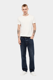 Modello indossa T-shirt bianca regular fit Follower SRL con girocollo, abbinata a jeans blu scuro e sneakers bianche