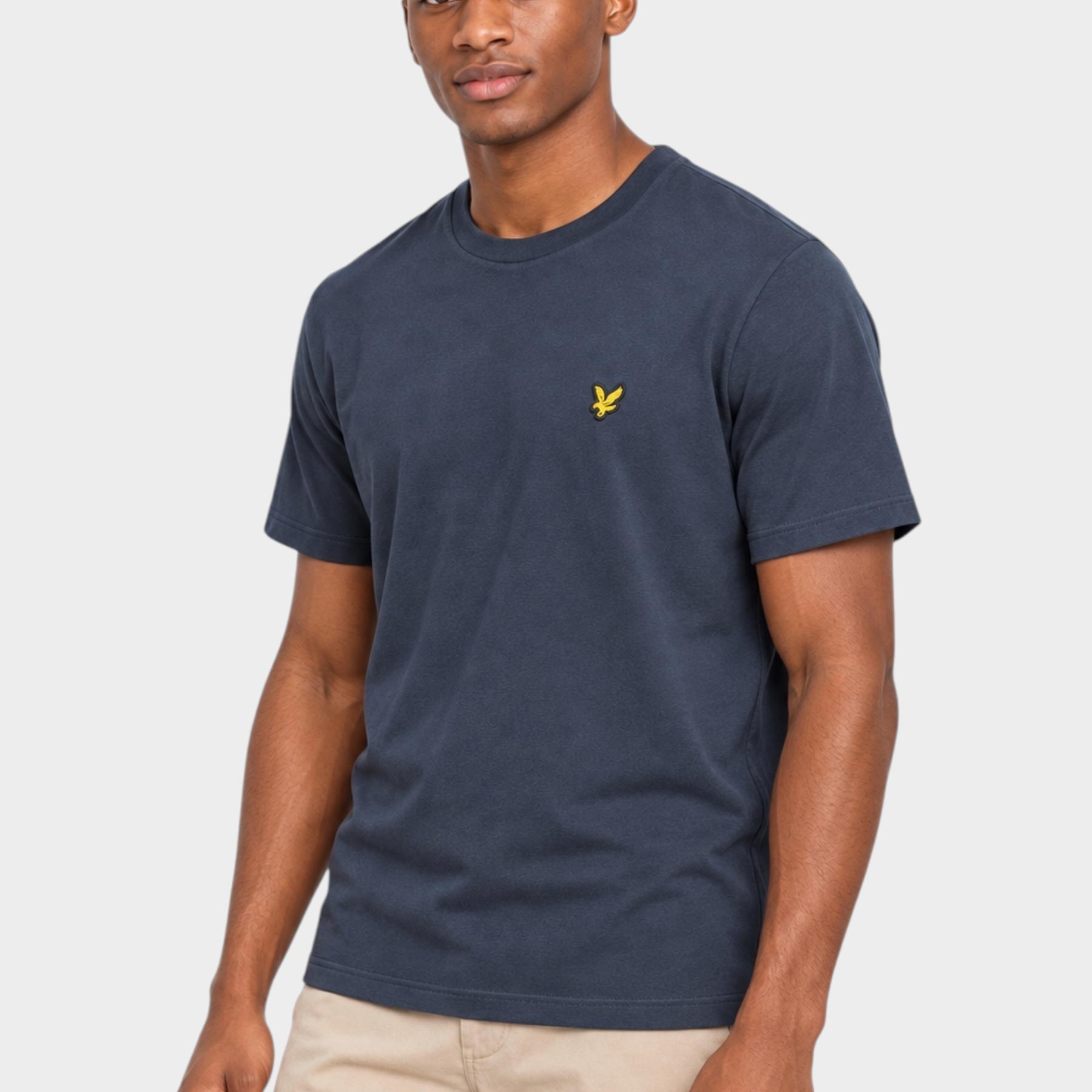 Modello indossa t-shirt blu scuro LYLE & SCOTT con logo giallo sul petto, proposta da Follower SRL