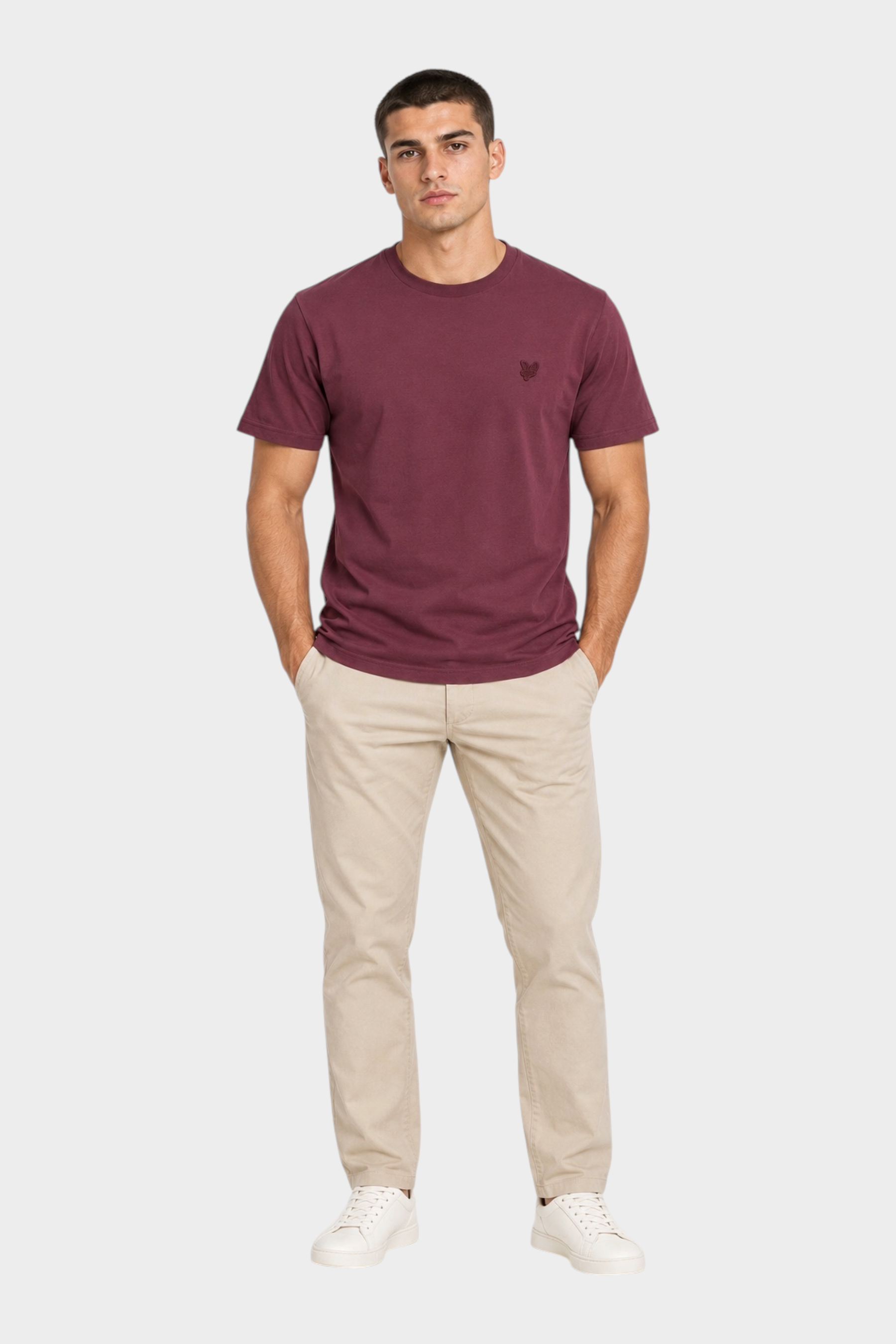 Modello indossa t-shirt bordeaux LYLE & SCOTT con logo ricamato, abbinata a pantaloni chino beige, Follower SRL