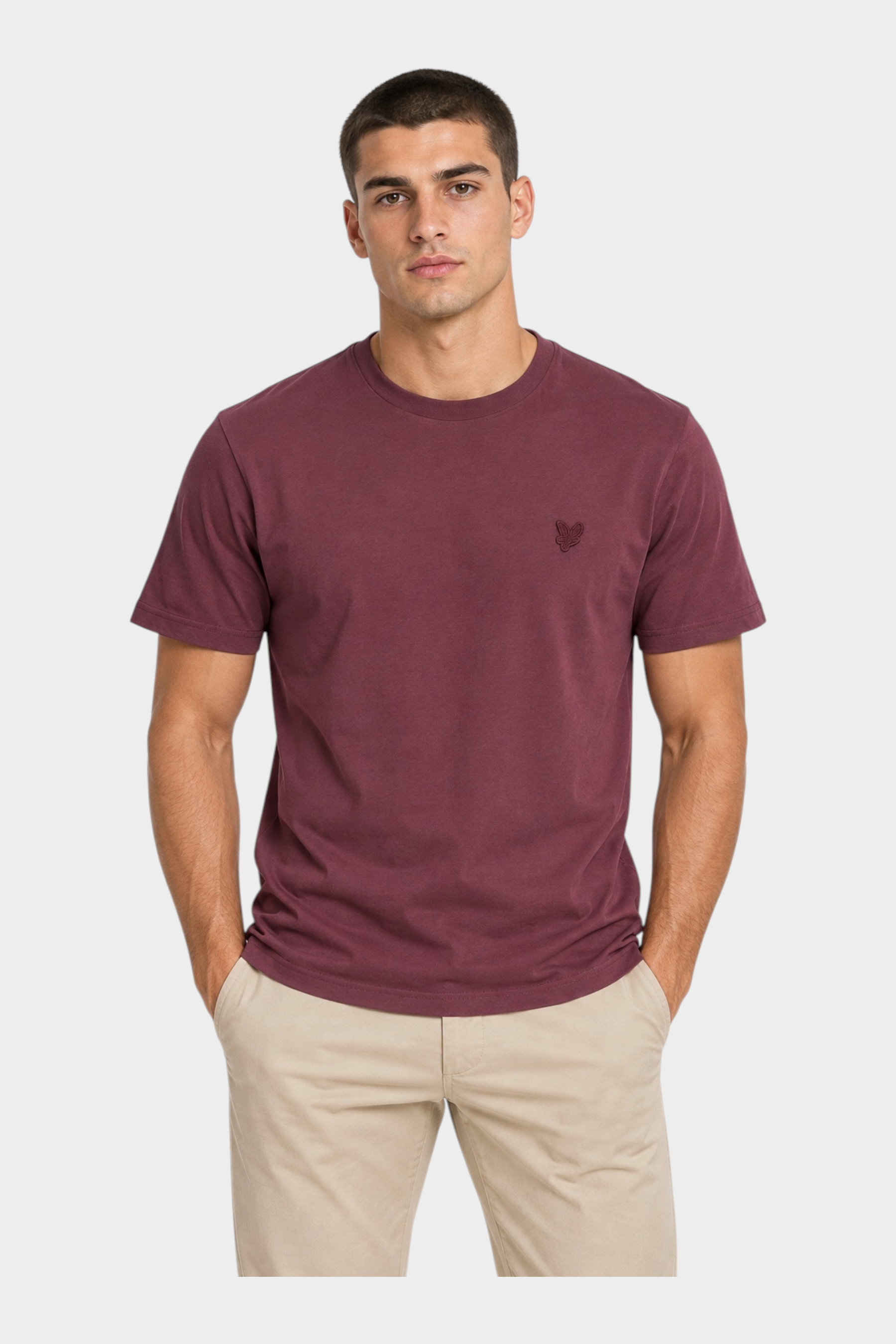 Modello indossa t-shirt bordeaux Follower SRL con logo ricamato sul petto e girocollo, abbinata a pantaloni beige