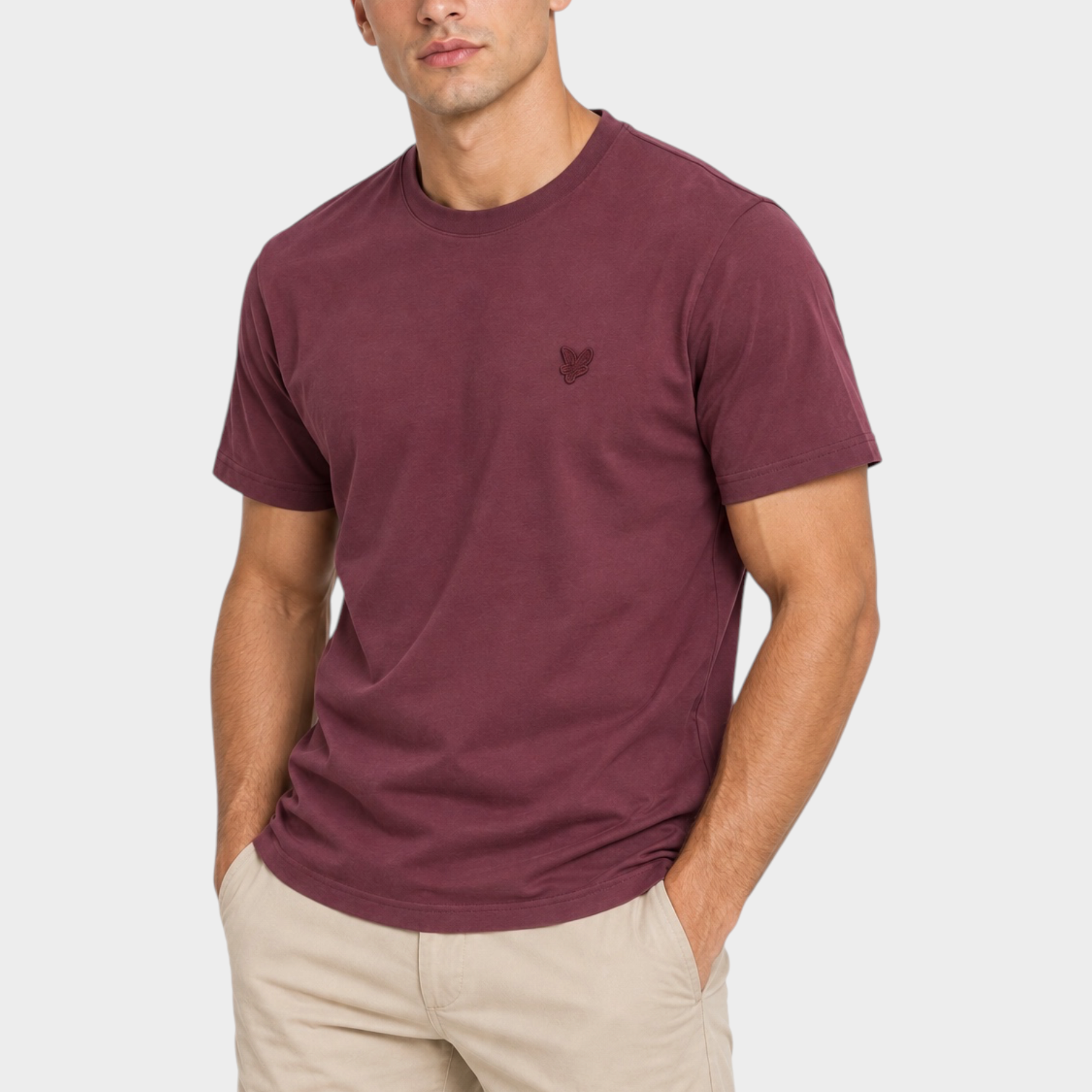 Modello indossa t-shirt bordeaux Follower SRL con logo ricamato e girocollo, abbinata a pantaloni beige