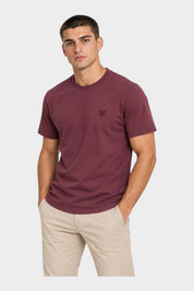 Modello indossa t-shirt bordeaux Follower SRL con logo ricamato e girocollo, abbinata a pantaloni beige