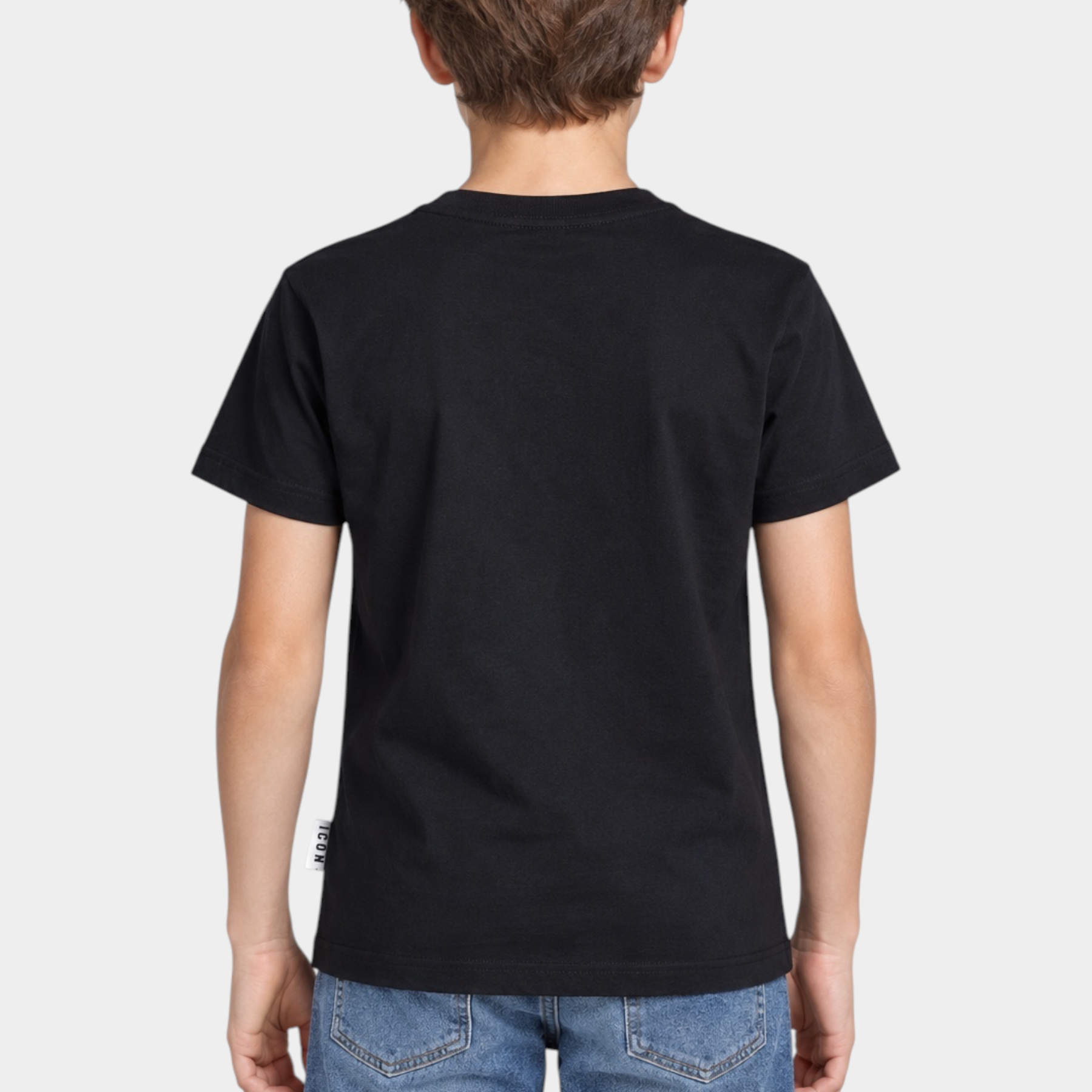 Ragazzo di spalle indossa una t-shirt nera Follower SRL con etichetta ICON sul fianco e jeans blu