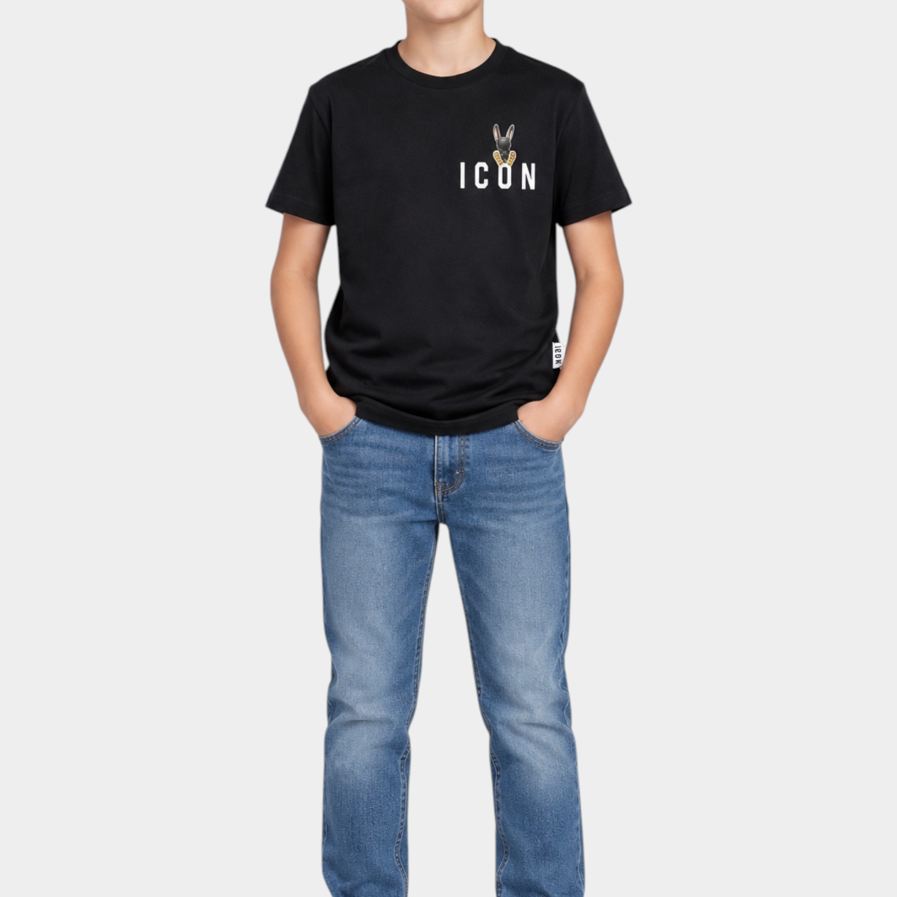 Ragazzo indossa una T-shirt nera Follower SRL con logo ICON sul petto, jeans blu e scarpe da ginnastica bianche
