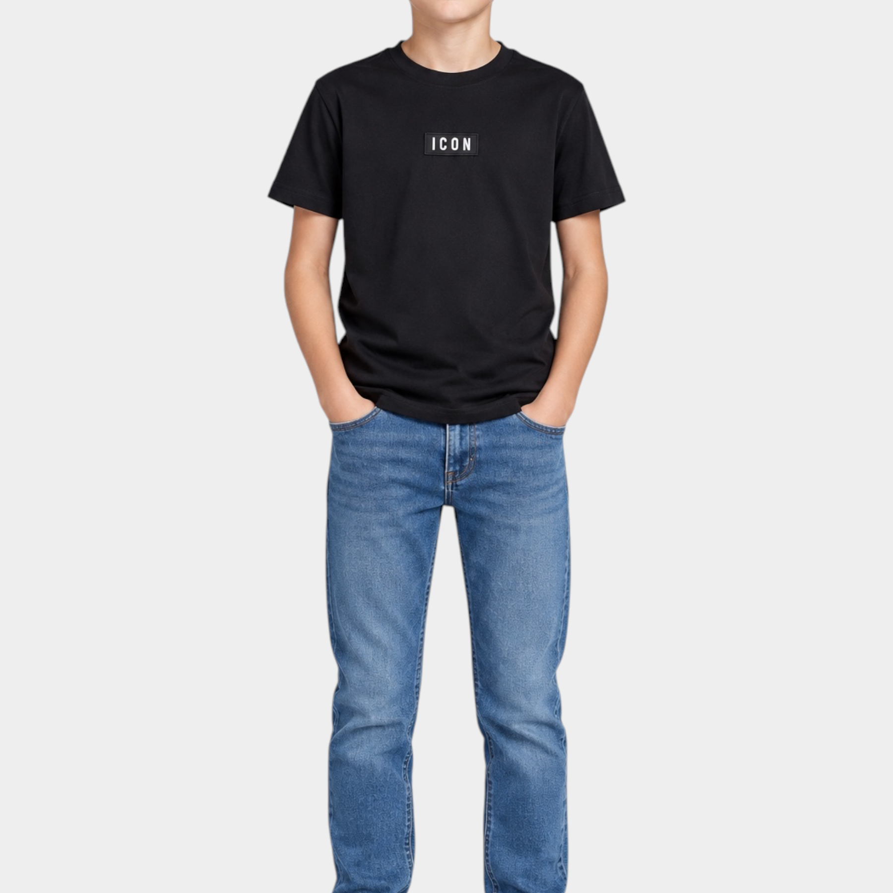 Ragazzo indossa una t-shirt nera Follower SRL con logo ICON bianco sul petto, jeans blu e sneakers bianche