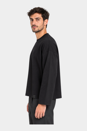 Modello indossa t-shirt nera a manica lunga boxy fit IMPERIAL di Follower SRL con taglio moderno e vestibilità ampia