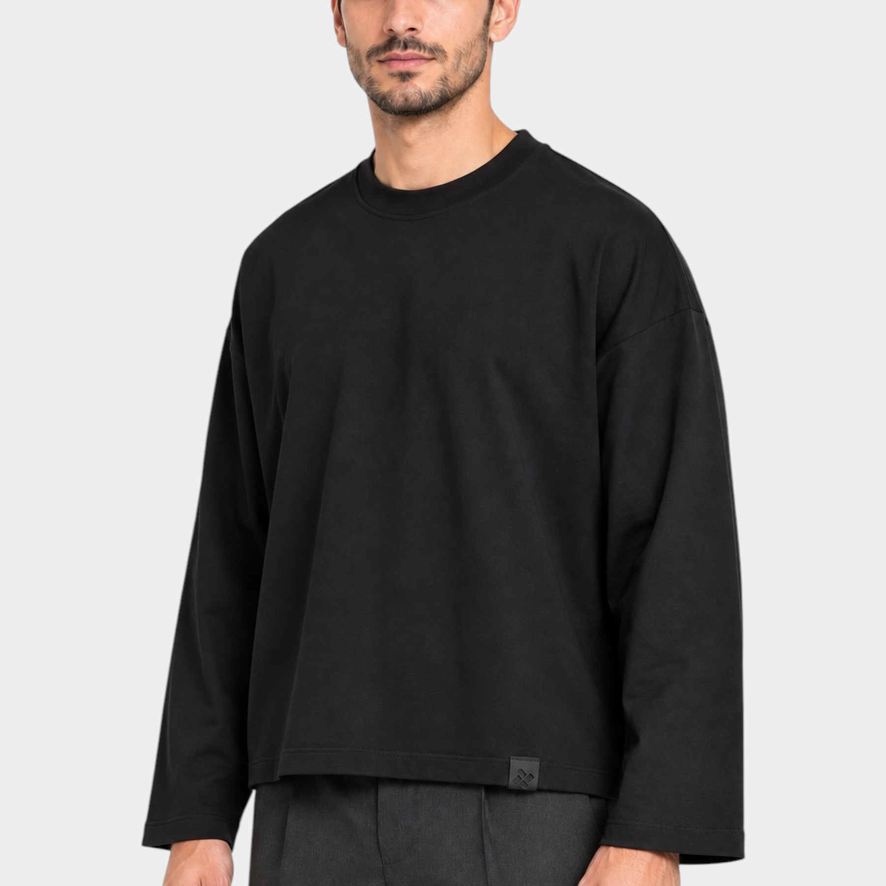 Modello indossa una t-shirt nera a manica lunga con vestibilità boxy fit del brand Follower SRL