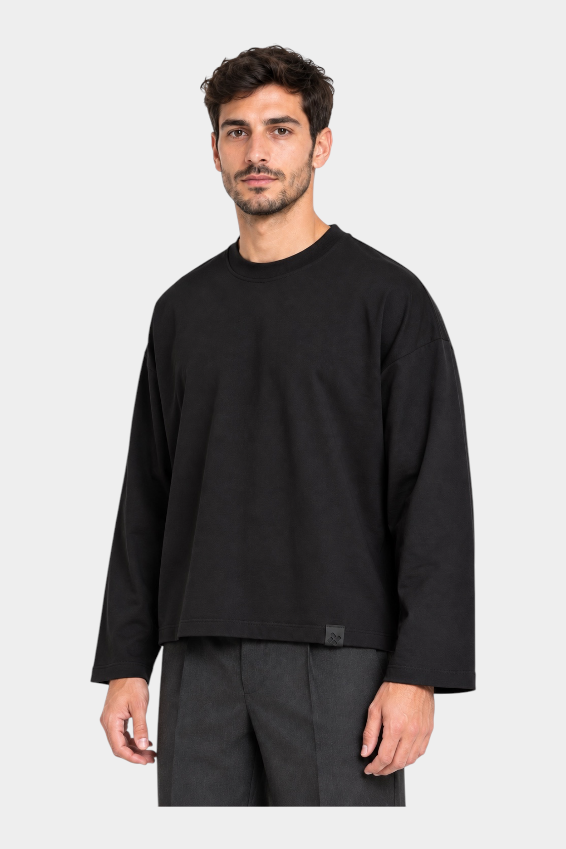 Modello indossa una t-shirt nera a manica lunga con vestibilità boxy fit del brand Follower SRL