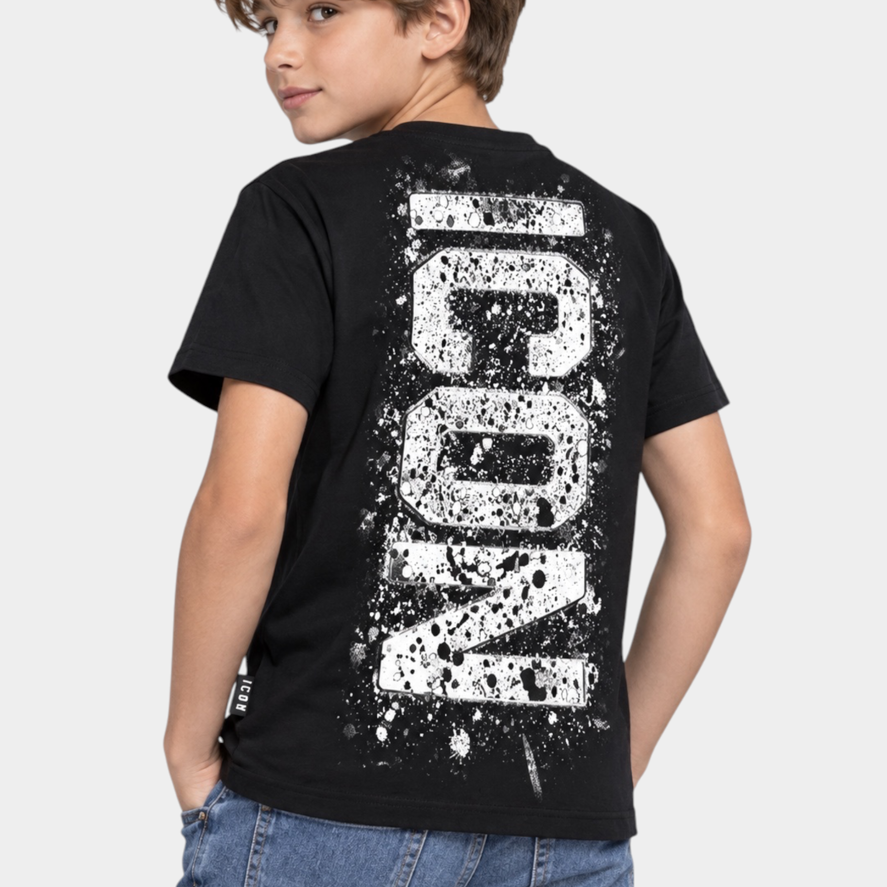 Ragazzo indossa una t-shirt nera Follower SRL con stampa ICON bianca effetto vernice spray sul retro