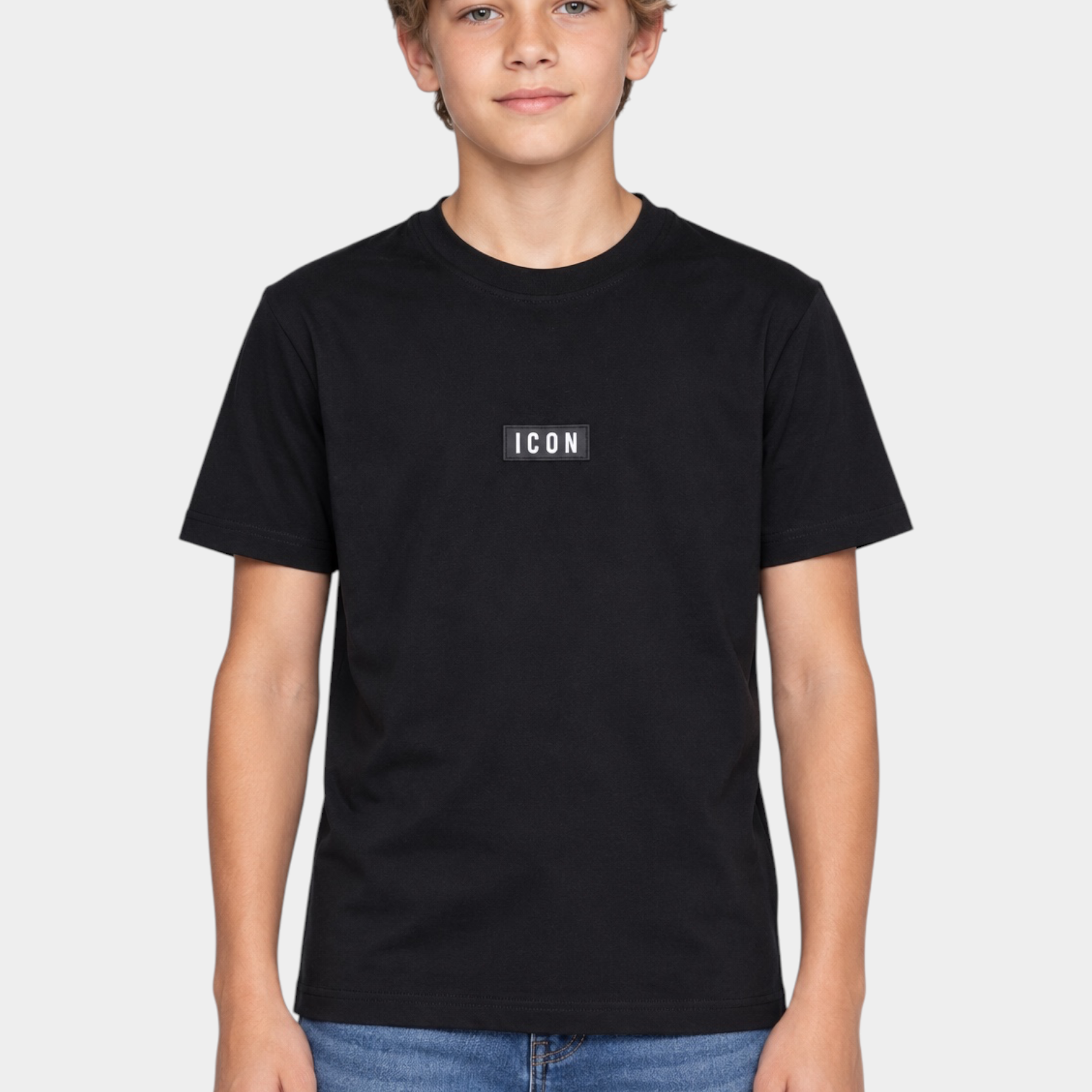 Ragazzo indossa una t-shirt nera Follower SRL in cotone con logo ICON rettangolare bianco sul petto