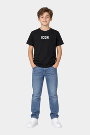 Ragazzo indossa una T-shirt nera Follower SRL con scritta ICON bianca, jeans blu e sneakers bianche