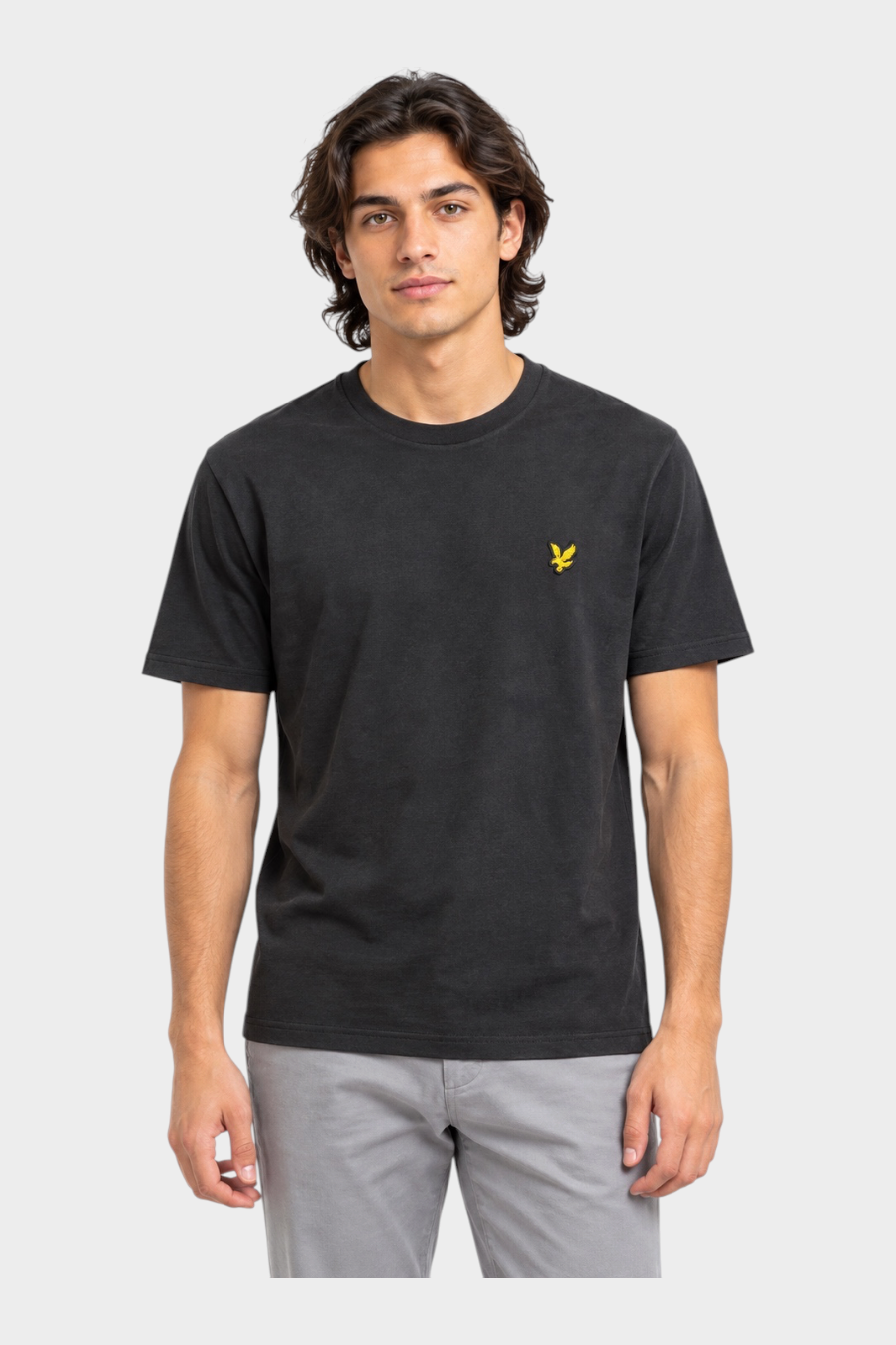 Modello indossa t-shirt nera Follower SRL Lyle & Scott con logo giallo ricamato sul petto e girocollo