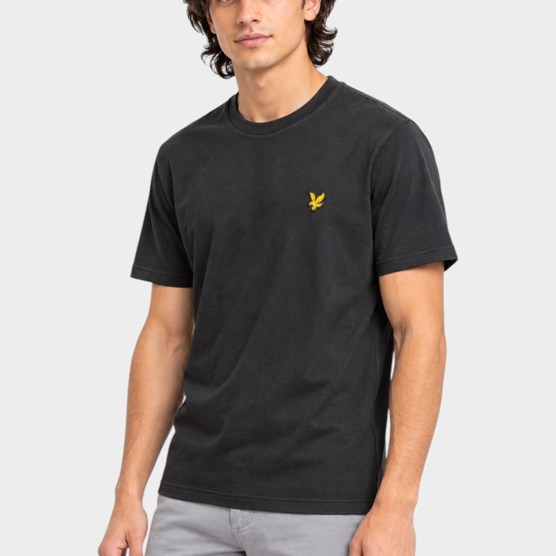 Modello indossa t-shirt nera Follower SRL Lyle & Scott con logo aquila giallo sul petto