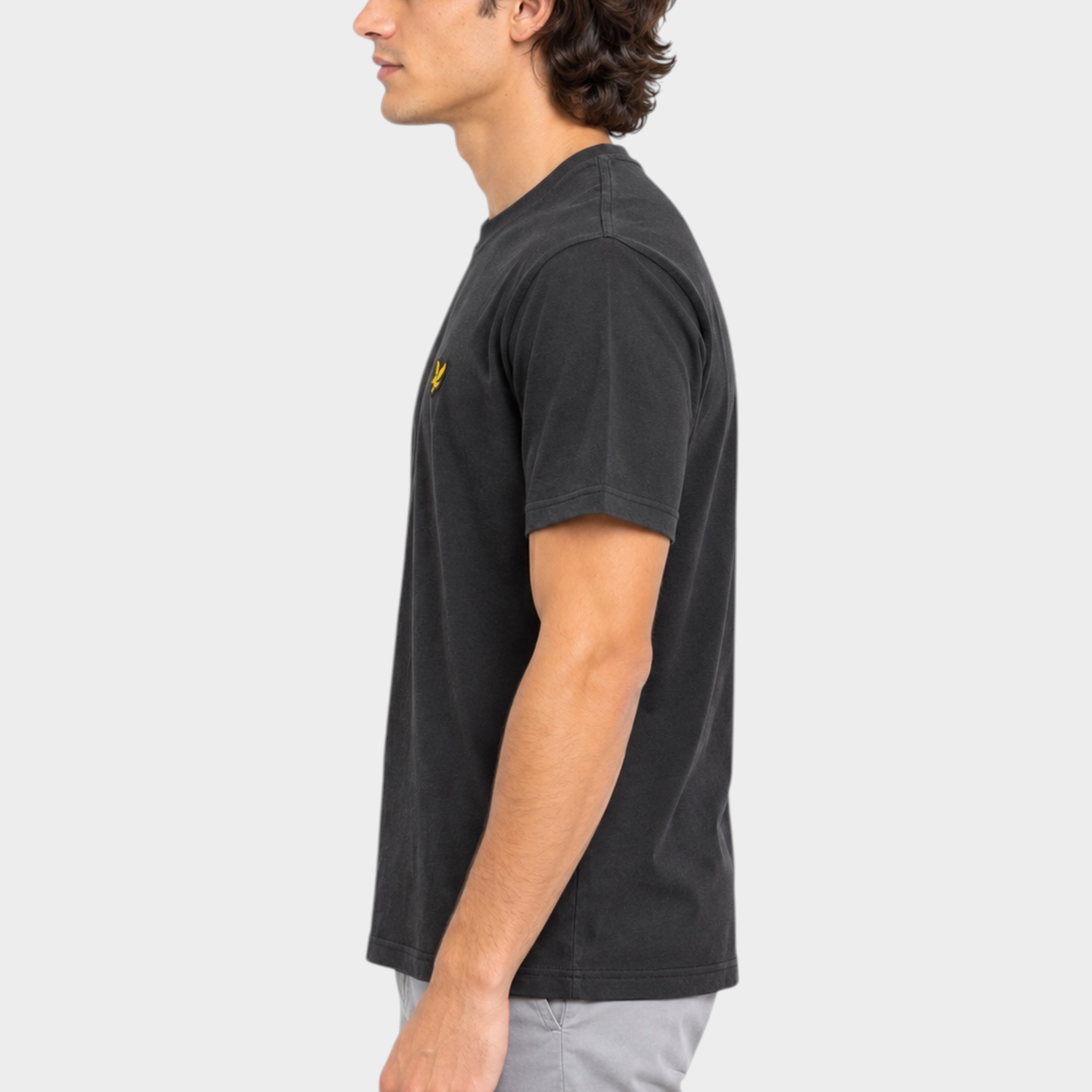 Modello di profilo indossa una t-shirt nera Follower SRL Lyle & Scott con logo giallo sul petto