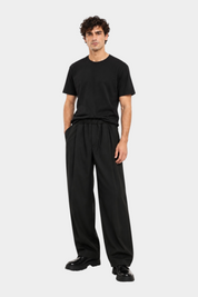 Modello indossa t-shirt nera regular fit IMPERIAL con pantaloni ampi neri, proposta da Follower SRL
