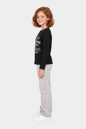 Bambina indossa t-shirt nera a maniche lunghe Follower SRL con scritta gioiello in strass e jeans grigi