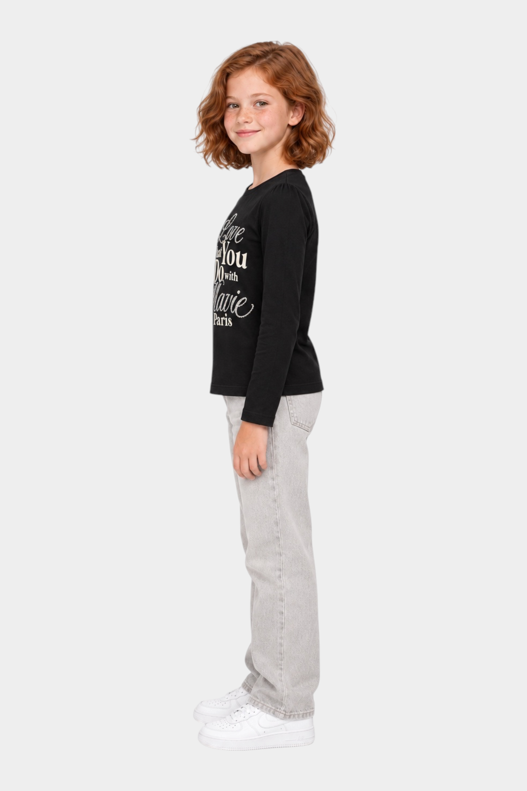 Bambina indossa t-shirt nera a maniche lunghe Follower SRL con scritta gioiello in strass e jeans grigi