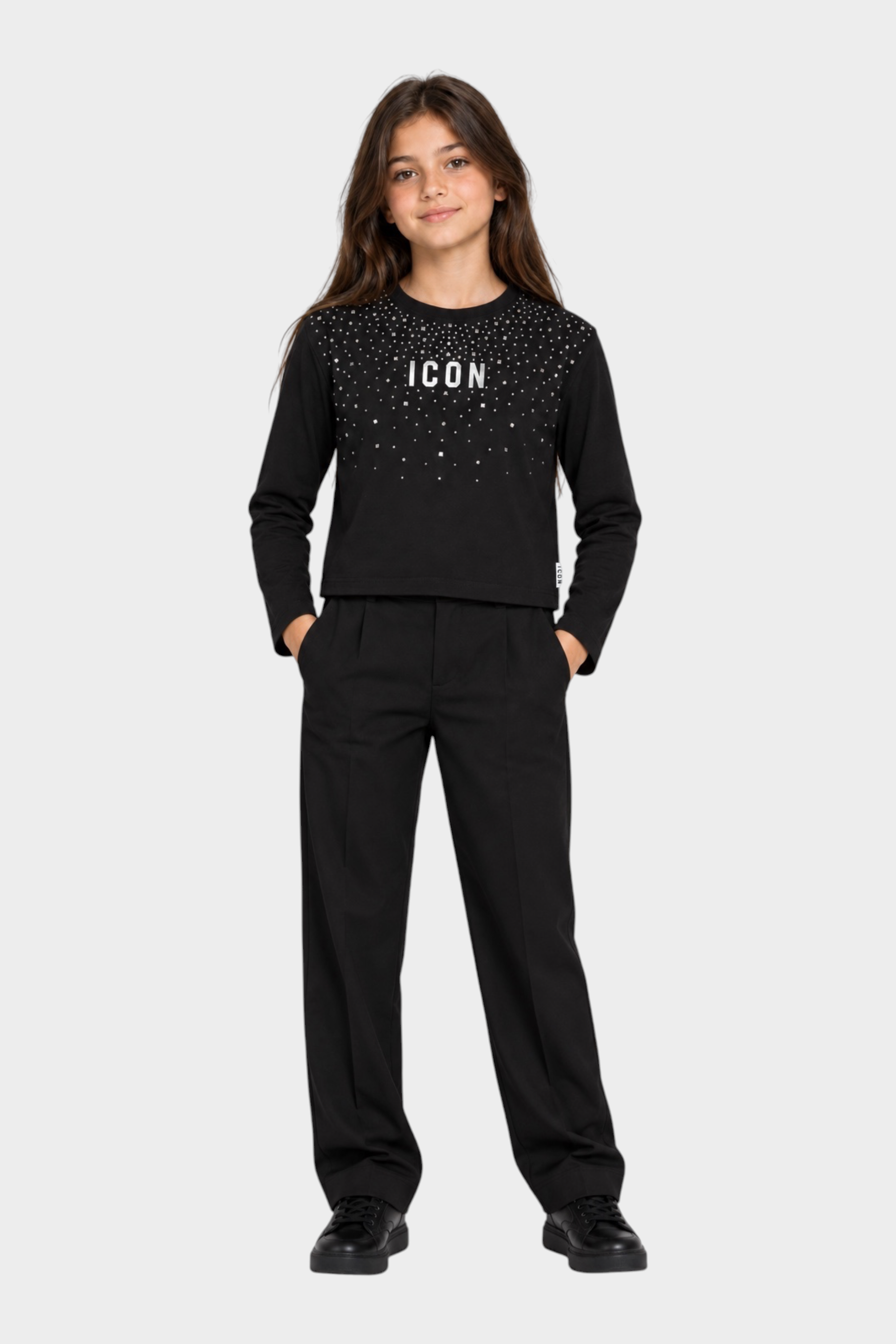 Bambina indossa t-shirt Follower SRL nera boxy con strass e scritta ICON, abbinata a pantaloni neri