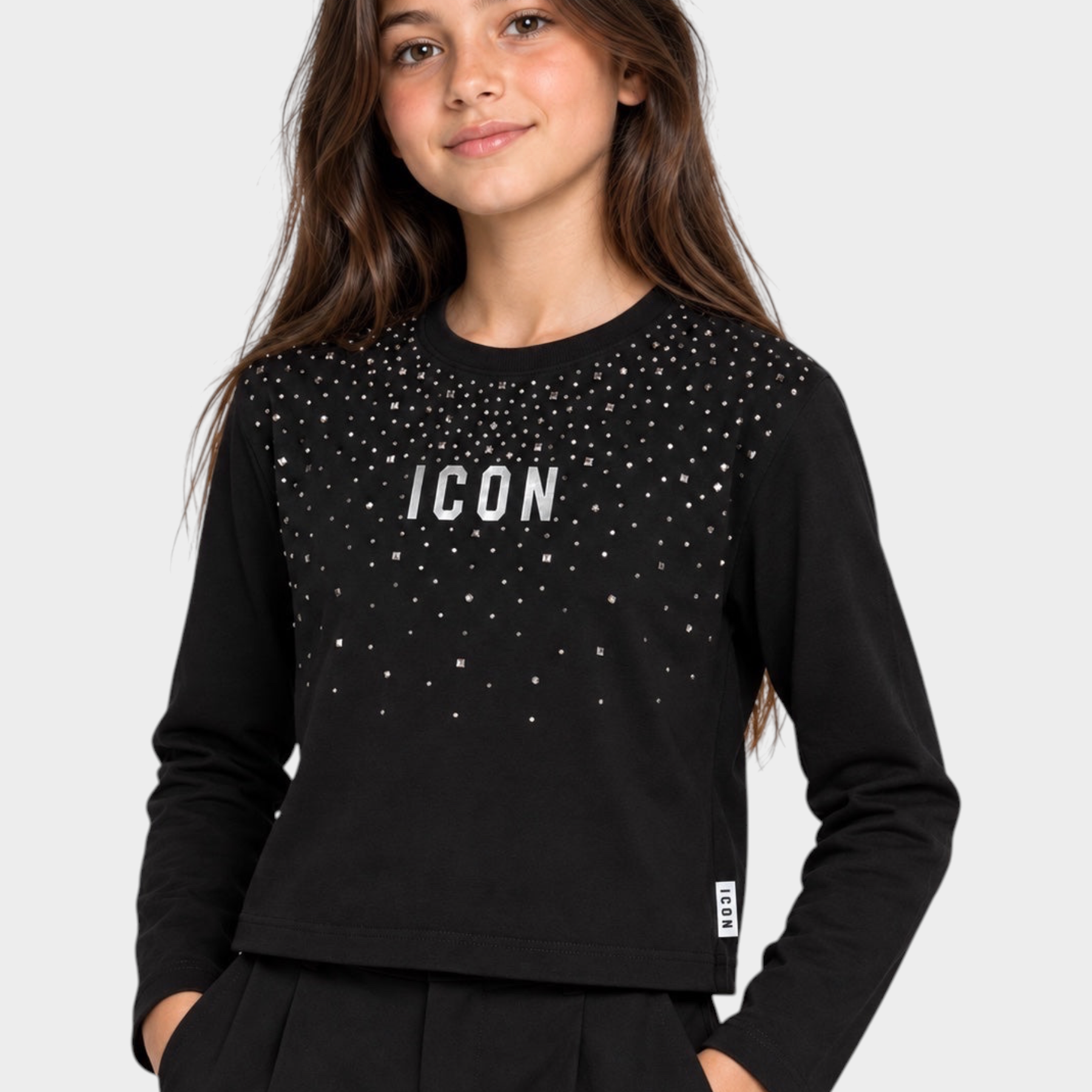 Ragazza indossa una t-shirt boxy nera Follower SRL a maniche lunghe con decorazioni di strass e scritta ICON