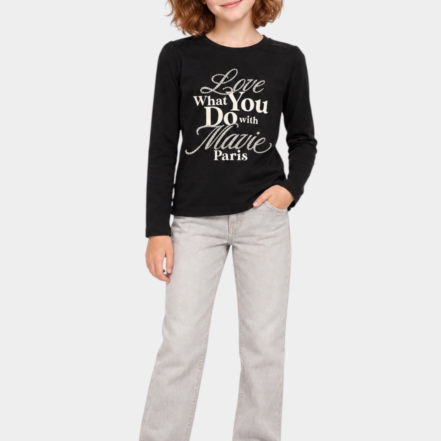 Bambina indossa t-shirt nera a maniche lunghe Follower SRL con scritta gioiello in strass e jeans grigi
