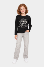 Bambina indossa t-shirt nera a maniche lunghe Follower SRL con scritta gioiello in strass e jeans grigi