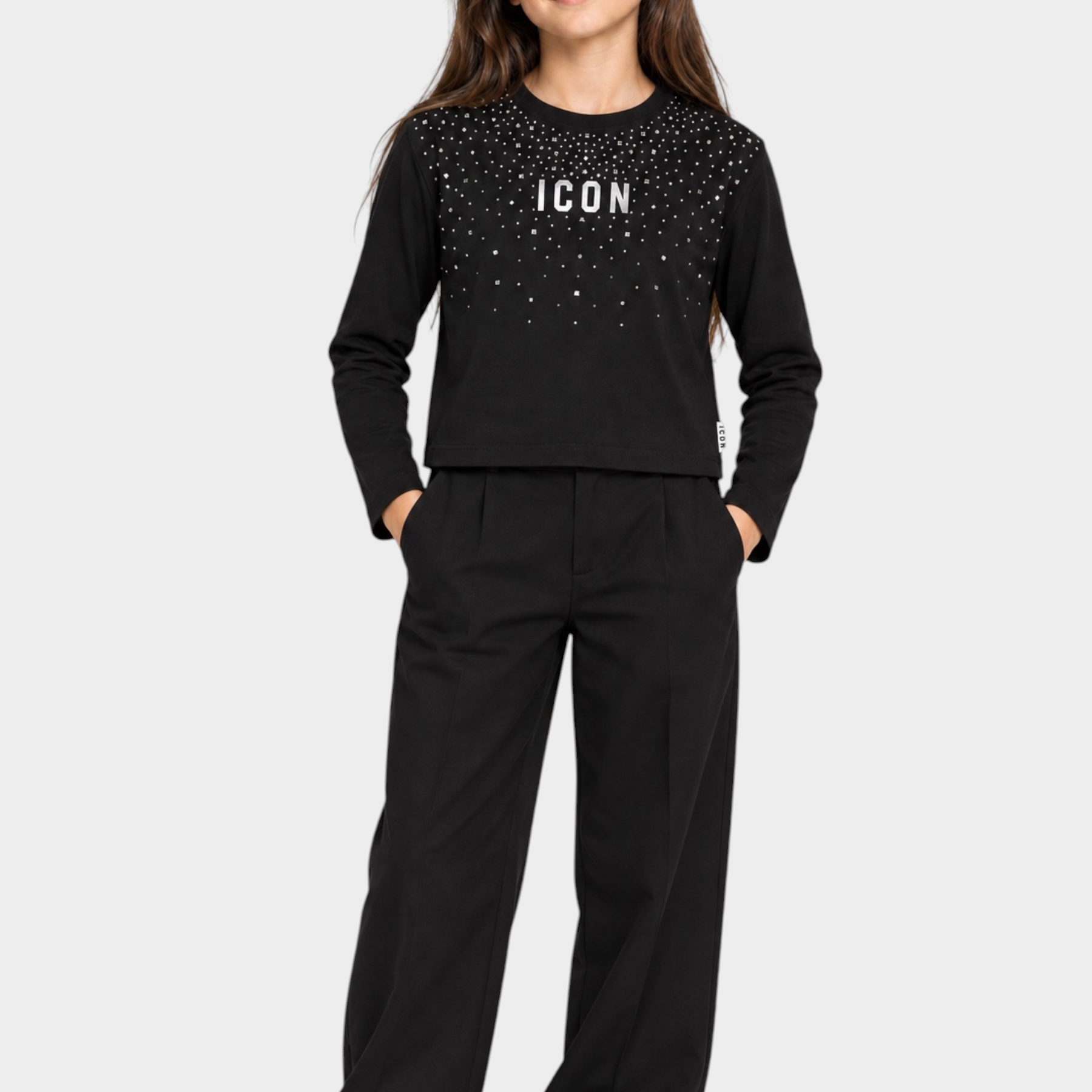 Bambina indossa t-shirt Follower SRL nera boxy con strass e scritta ICON, abbinata a pantaloni neri a gamba larga