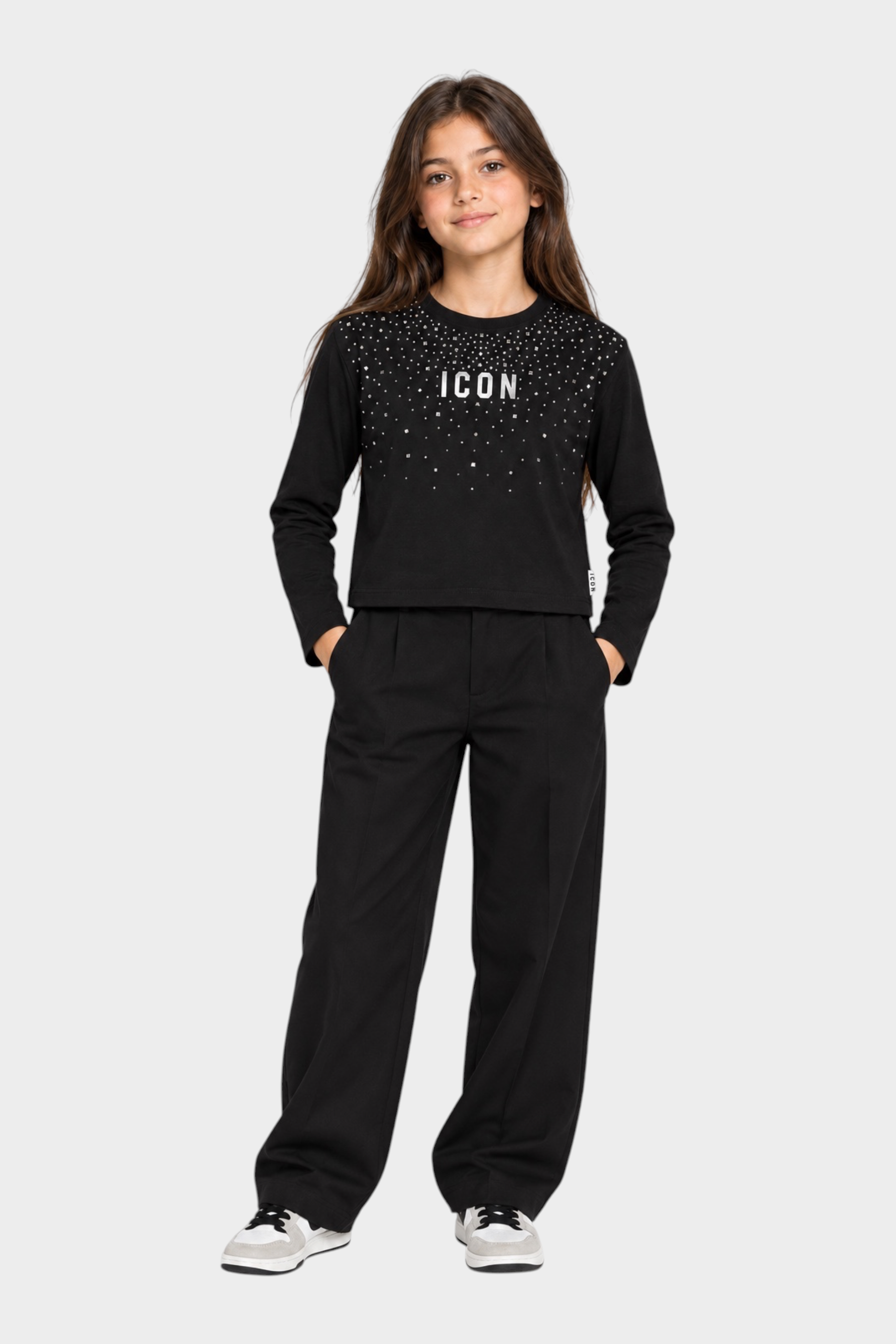 Bambina indossa t-shirt Follower SRL nera boxy con strass e scritta ICON, abbinata a pantaloni neri a gamba larga