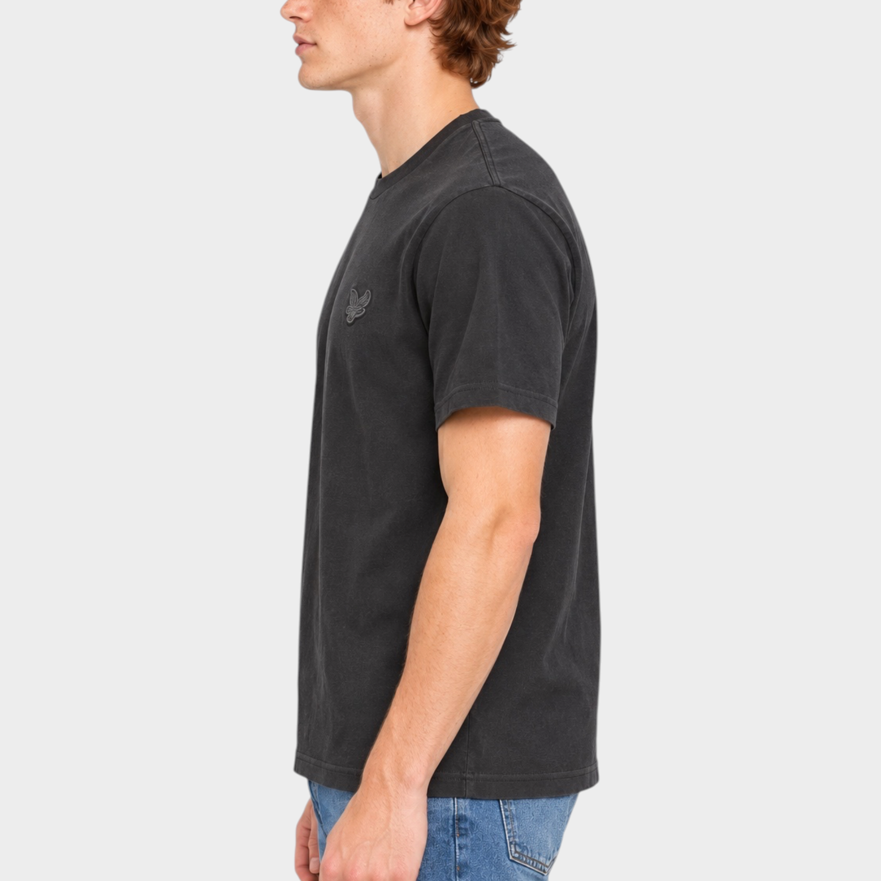 Modello di profilo indossa una t-shirt nera Follower SRL LYLE & SCOTT con logo sul petto e jeans