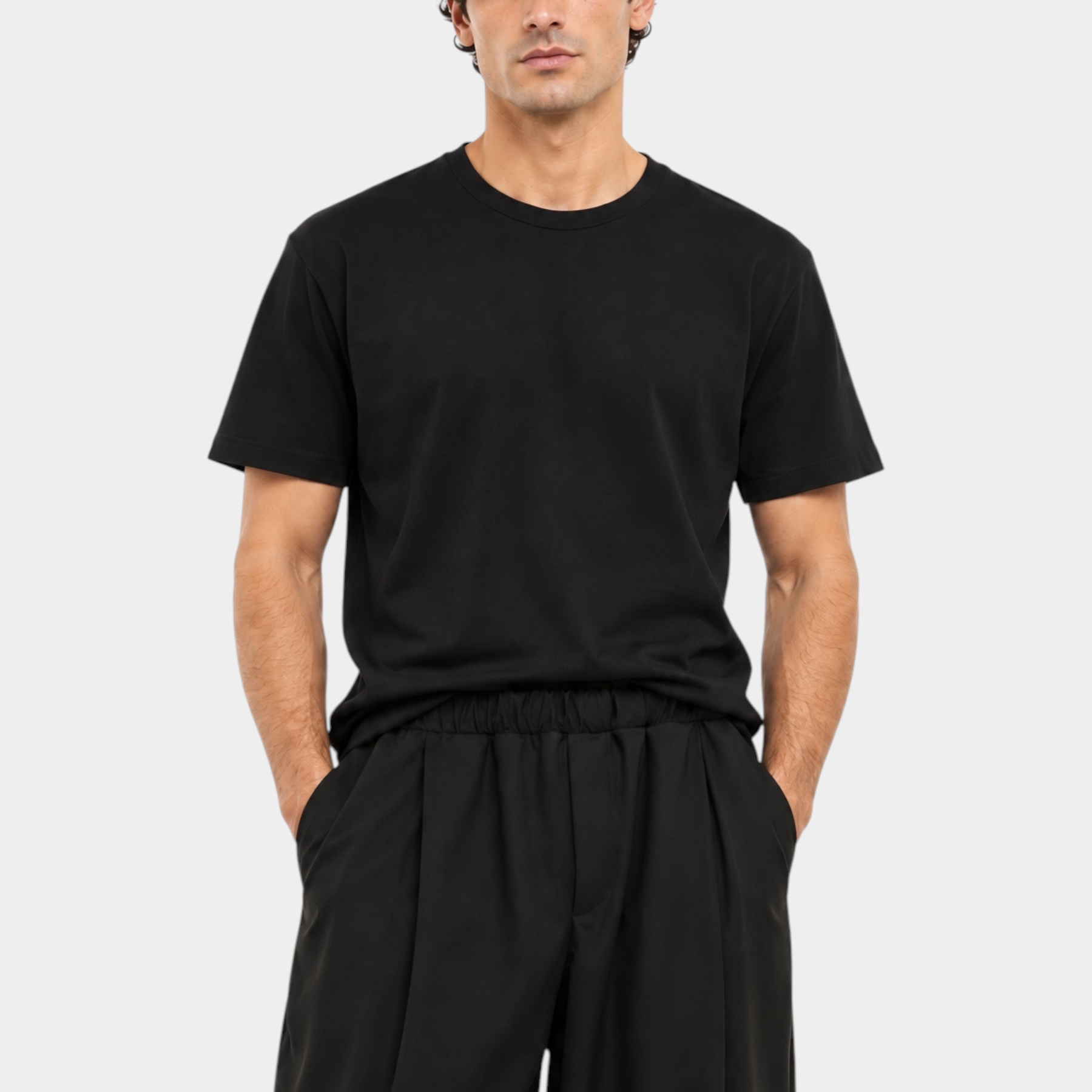 Modello indossa una t-shirt nera a girocollo regular fit di Follower SRL su sfondo bianco