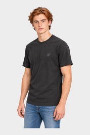 Modello indossa t-shirt nera in cotone Follower SRL con logo Lyle & Scott sul petto e jeans blu