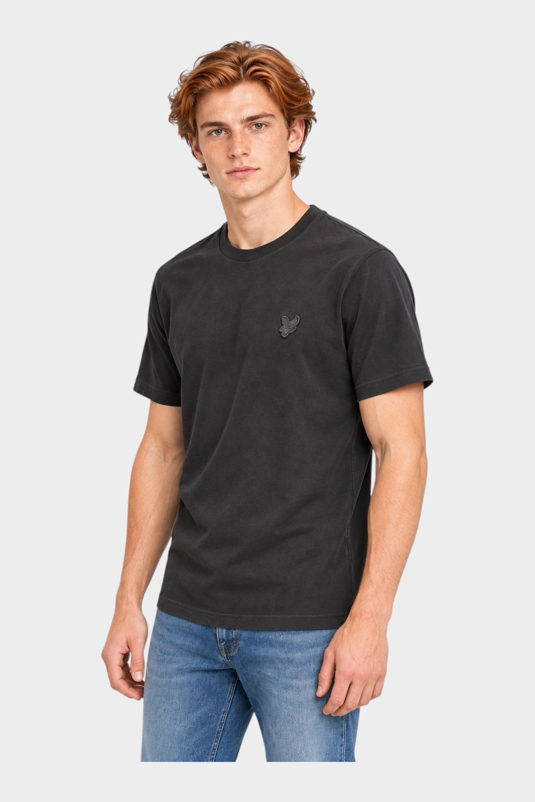 Modello indossa t-shirt nera in cotone Follower SRL con logo Lyle & Scott sul petto e jeans blu