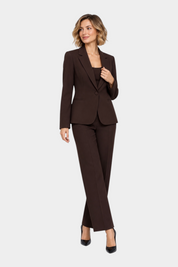 Modella indossa un tailleur marrone Follower SRL con giacca avvitata e pantaloni a gamba dritta su sfondo neutro