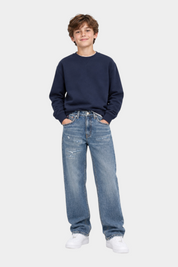 Ragazzo indossa jeans Follower SRL Tommy Hilfiger barrel fit blu con effetto vintage e dettagli consumati