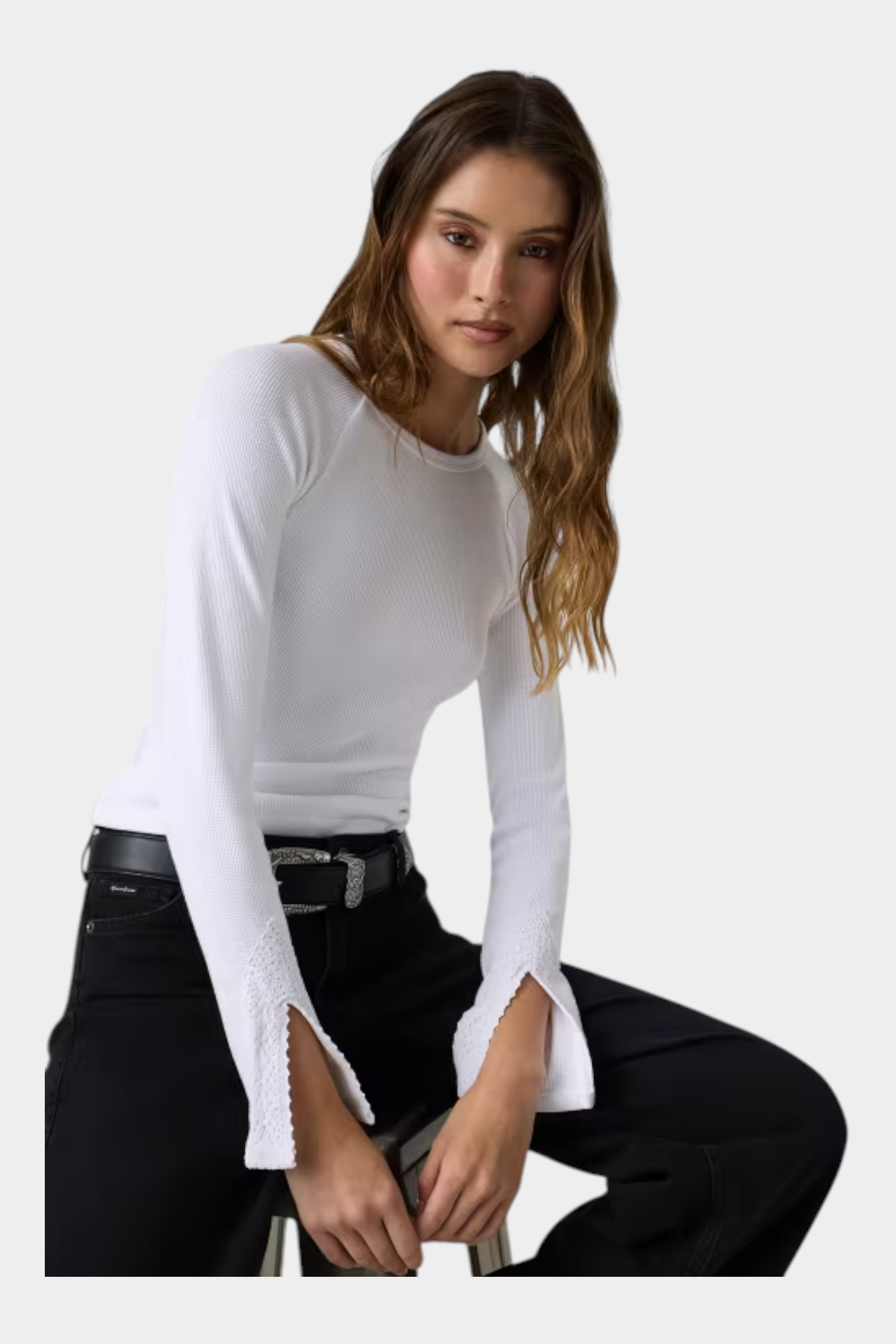 Modella indossa un top bianco a maniche lunghe Follower SRL con dettagli in pizzo sui polsini e scollo rotondo