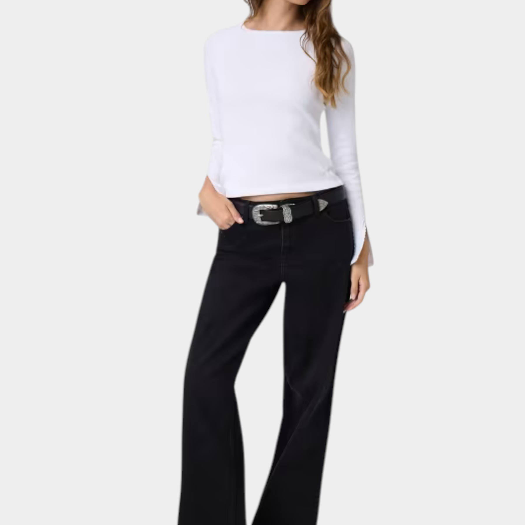 Modella indossa top bianco a maniche lunghe con dettagli in pizzo e jeans neri a zampa Follower SRL