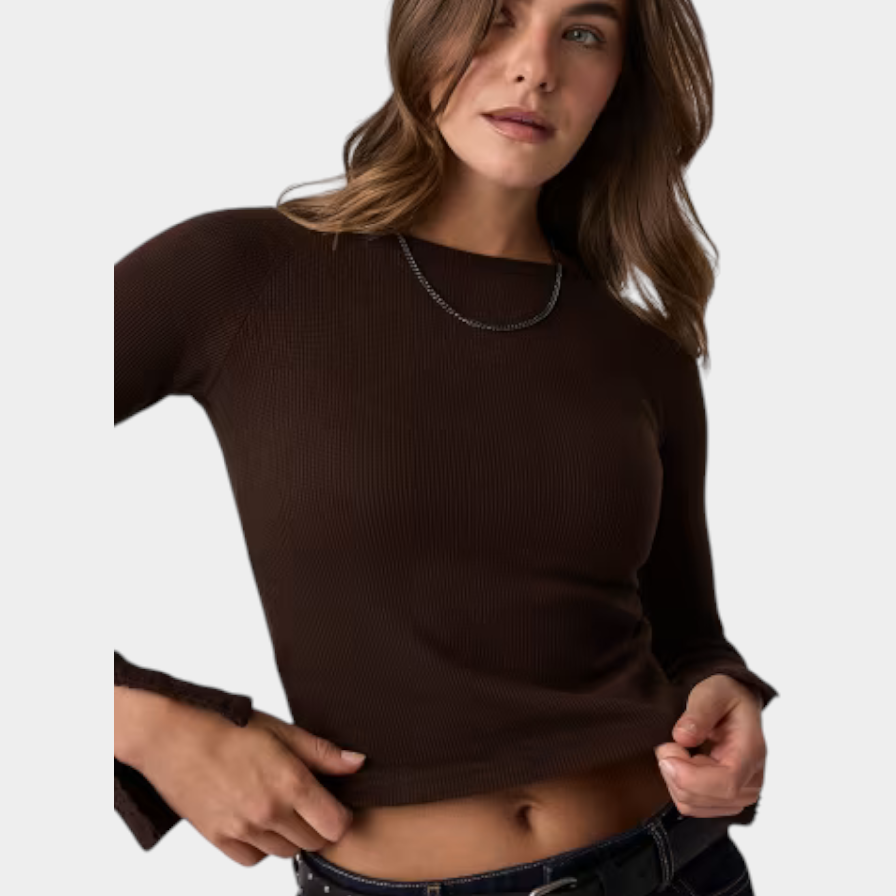Modella indossa un top a maniche lunghe marrone a coste Follower SRL con scollo rotondo e dettagli sui polsini