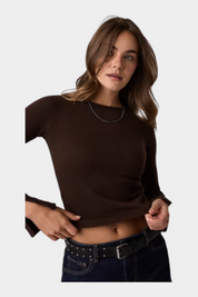 Modella indossa un top a maniche lunghe marrone a coste Follower SRL con scollo rotondo e dettagli sui polsini