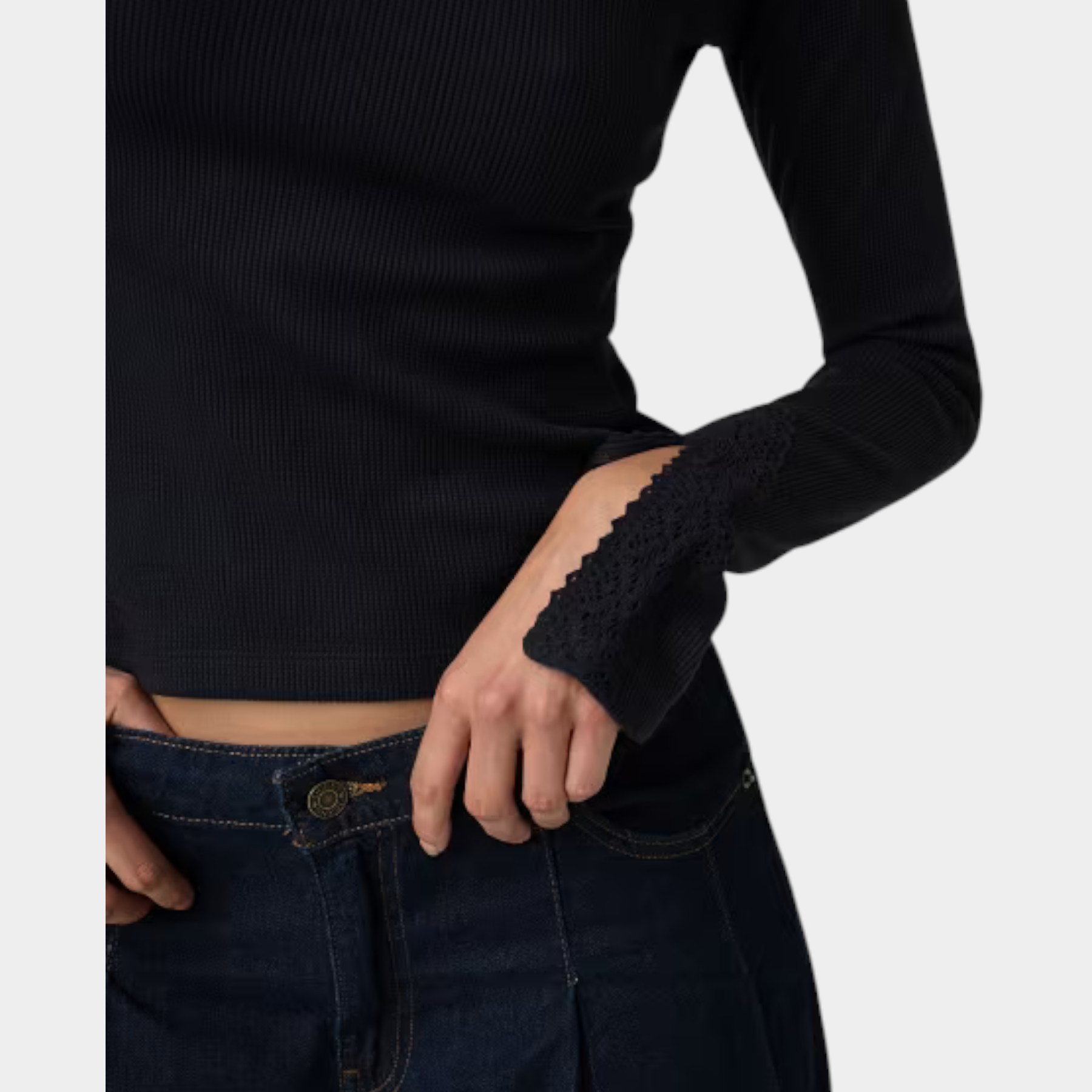 Top nero a coste Follower SRL con maniche lunghe e dettagli in pizzo sui polsini, abbinato a jeans scuri