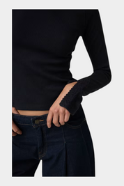 Top nero a coste Follower SRL con maniche lunghe e dettagli in pizzo sui polsini, abbinato a jeans scuri